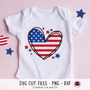 May include: White baby onesie with a red, white, and blue heart-shaped American flag design. The heart is outlined in black and surrounded by small red, white, and blue stars.