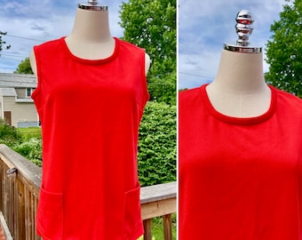 May include: A sleeveless red dress with a round neckline and two pockets. The dress is on a mannequin.