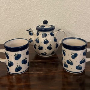 May include: A set of three ceramic mugs with a speckled, matte finish. The mugs are in shades of cream, light gray, and dark gray. Each mug has a simple, minimalist design, perfect for coffee or tea.