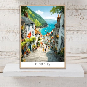 Pode incluir: Uma impressão artística vertical que retrata uma rua íngreme de paralelepípedos em Clovelly, ladeada por edifícios brancos, colinas verdes e bandeiras coloridas. O caminho desce em direção a um mar azul com veleiros sob um céu claro com o texto Clovelly.