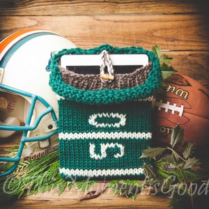 May include: Green and white knitted tablet sleeve with a brown knit lining. The sleeve has a white stripe with the letters "GO" and a white stripe with the letters "U.S."
