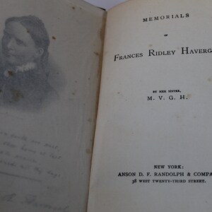 May include: A black and white portrait of Frances Ridley Havergal, the author of the book "Memorials of Frances Ridley Havergal". The book cover features the title, author, and publisher information.