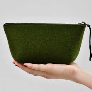 May include: A dark green felt zippered pouch with a black zipper pull and a black cord.