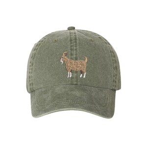 May include: A green, cotton baseball cap with an embroidered brown goat on the front.