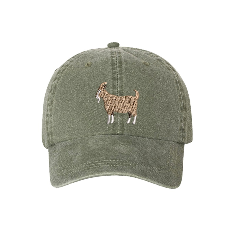 May include: A green, cotton baseball cap with an embroidered brown goat on the front.