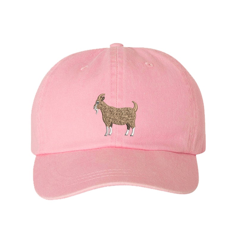 May include: A pink baseball cap with an embroidered brown goat on the front.