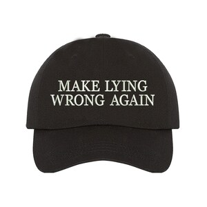 May include: Black baseball cap with the embroidered text "MAKE LYING WRONG AGAIN" in white. The cap has a curved brim and a rounded crown. A casual accessory for everyday wear.