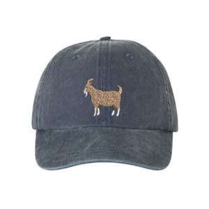 May include: A dark blue denim baseball cap with an embroidered brown goat on the front.