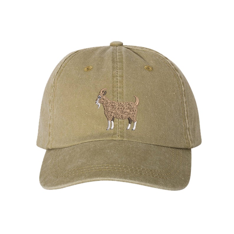 May include: A brown and beige baseball cap with an embroidered image of a brown goat on the front.