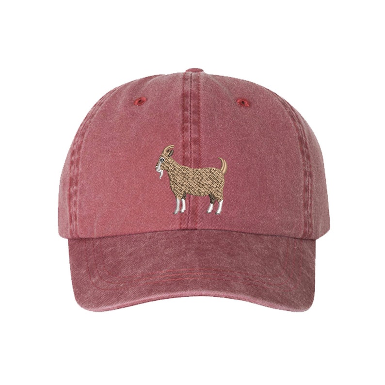 May include: A red, vintage-style baseball cap with an embroidered image of a brown goat.
