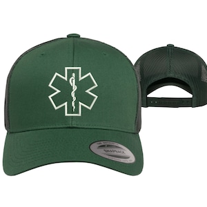 May include: A green and black trucker hat with a white embroidered medical symbol, the Star of Life, on the front. The hat has a mesh back and a snap closure.