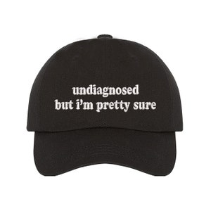 May include: Black baseball cap with white embroidered text that reads "undiagnosed but i'm pretty sure".