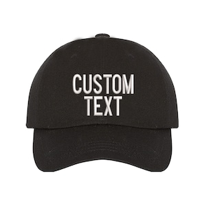 May include: A black baseball cap with white embroidered text that reads "CUSTOM TEXT".