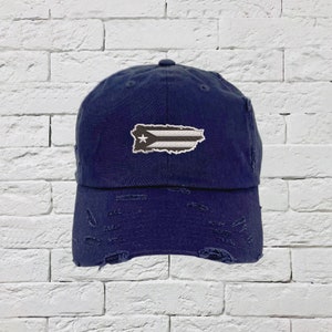 May include: A navy blue distressed baseball cap with a white and gray Puerto Rican flag patch.