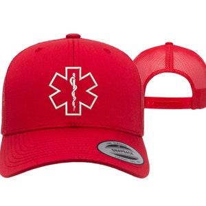 May include: Red trucker hat with a white embroidered medical symbol, the Star of Life, on the front. The hat has a mesh back and a snap closure.
