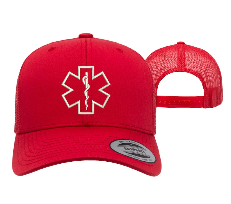 May include: Red trucker hat with a white embroidered medical symbol, the Star of Life, on the front. The hat has a mesh back and a snap closure.