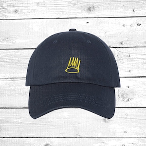 May include: A navy blue baseball cap with a yellow embroidered crown on the front.