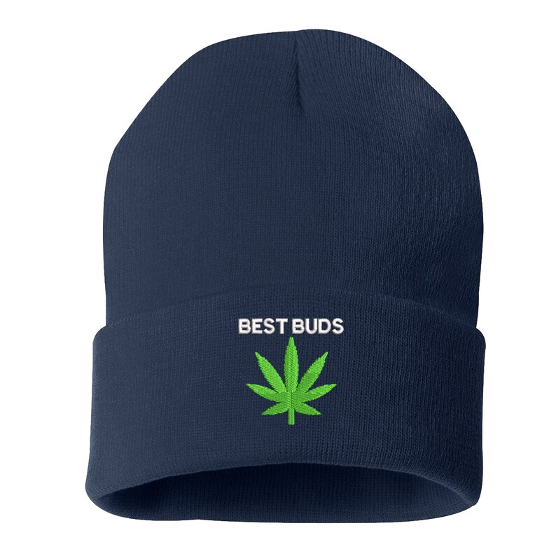 May include: Navy blue beanie hat with the embroidered text "BEST BUDS" above a green cannabis leaf. The hat is a classic, cuffed style, suitable for casual wear.