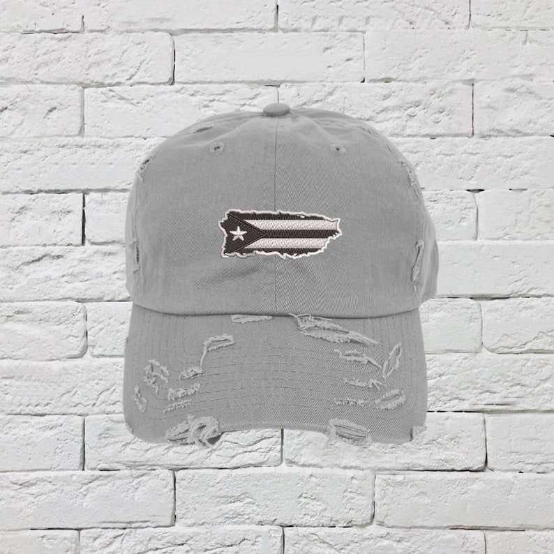 May include: A gray distressed baseball cap with a white and black Puerto Rican flag embroidered on the front.