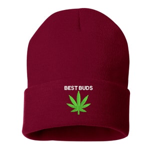 May include: A burgundy beanie with a folded brim. The text "BEST BUDS" is embroidered in white above a green cannabis leaf.
