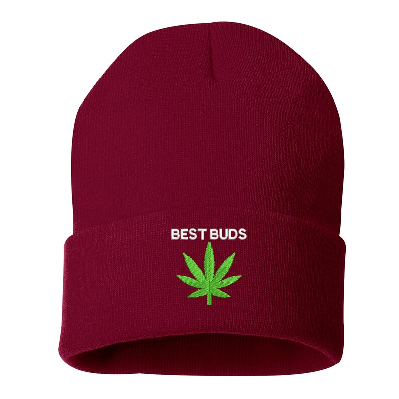 May include: A burgundy beanie with a folded brim. The text "BEST BUDS" is embroidered in white above a green cannabis leaf.