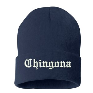 May include: A navy blue beanie with the word "Chingona" embroidered in white, gothic-style lettering. The beanie is a classic, close-fitting style, suitable for cold weather.