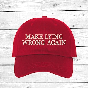 May include: Red baseball cap with white embroidered text that reads "Make Lying Wrong Again".