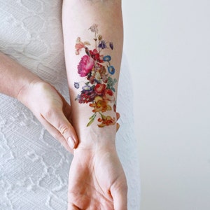 May include: A temporary tattoo featuring a colorful bouquet of flowers in shades of pink, red, orange, yellow, blue, and purple. The flowers are arranged in a vertical design, with the largest flower at the top and the smallest flowers at the bottom.