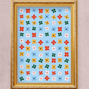 K&ouml;nnte beinhalten: Ein gerahmter Druck mit einem sich wiederholenden Muster aus bunten Blumen auf hellblauem Hintergrund. Der Rahmen ist golden mit einem dekorativen Rand.