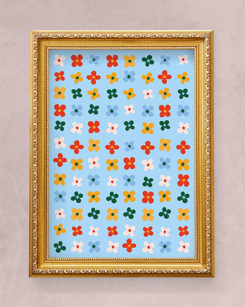 K&ouml;nnte beinhalten: Ein gerahmter Druck mit einem sich wiederholenden Muster aus bunten Blumen auf hellblauem Hintergrund. Der Rahmen ist golden mit einem dekorativen Rand.