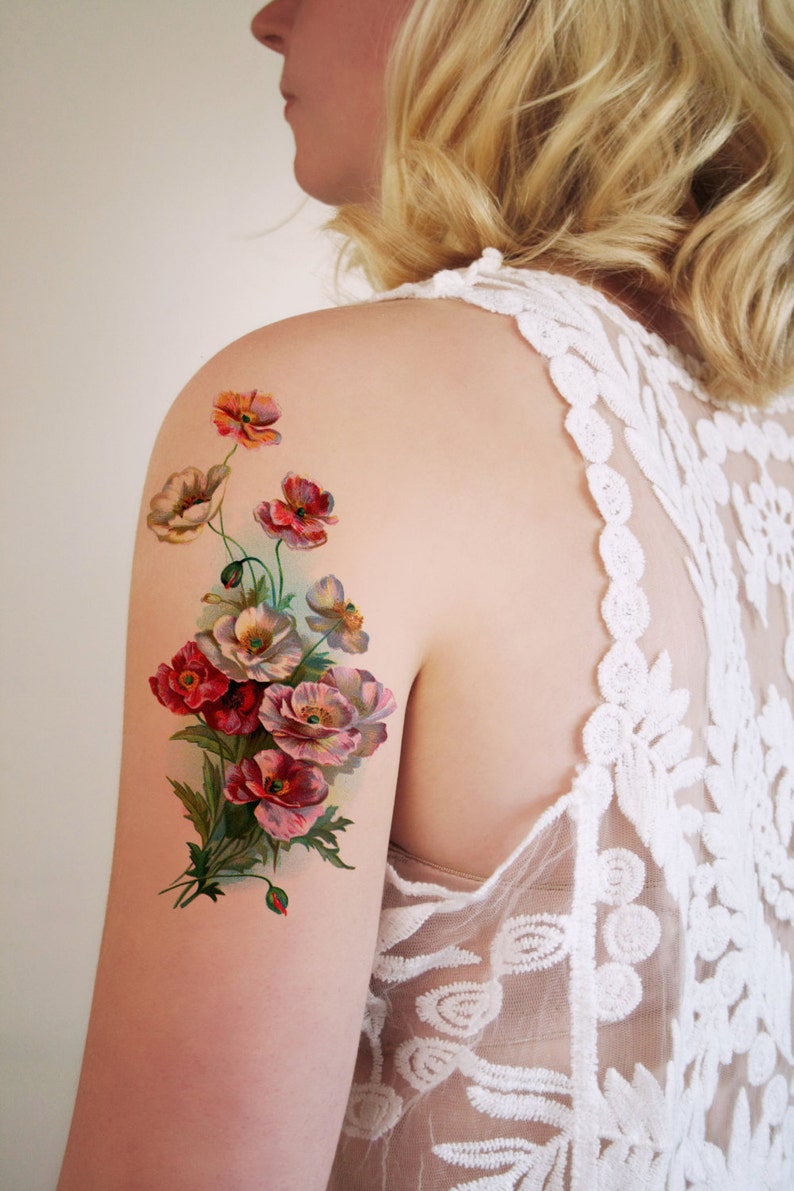 May include: A temporary tattoo featuring a bouquet of pink, red, and white flowers with green leaves. The flowers are painted in a vintage style.