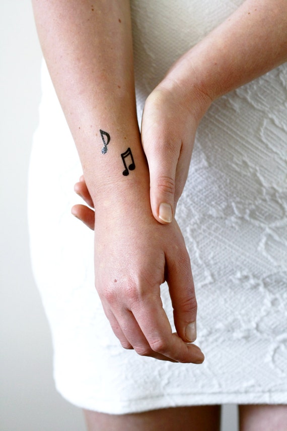 Cropped Image Of Man Hand With Music Theme Tattoo On Wrist Against Black  Background Stock Photo - Download Image Now - iStock