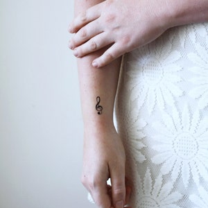 Puede incluir: Primer plano de un brazo con un peque&ntilde;o tatuaje de clave de sol en la mu&ntilde;eca.