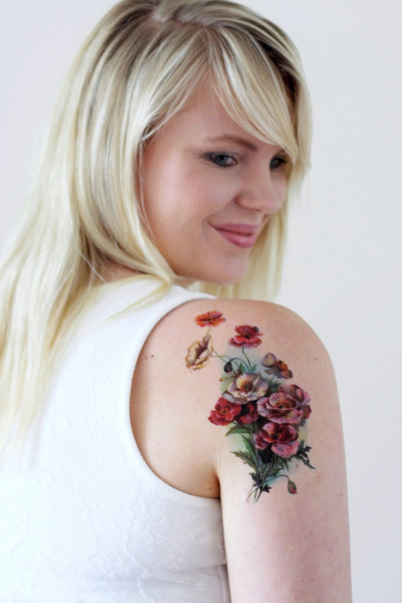 May include: A temporary tattoo featuring a bouquet of red, pink, and white flowers with green leaves. The flowers are arranged in a cluster and have a vintage style.
