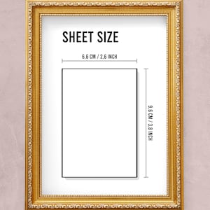 May include: A gold-colored frame with a white mat and black text that reads "SHEET SIZE" and "6.6 CM / 2.6 INCH" and "9.6 CM / 3.8 INCH". The frame is on a light pink background.