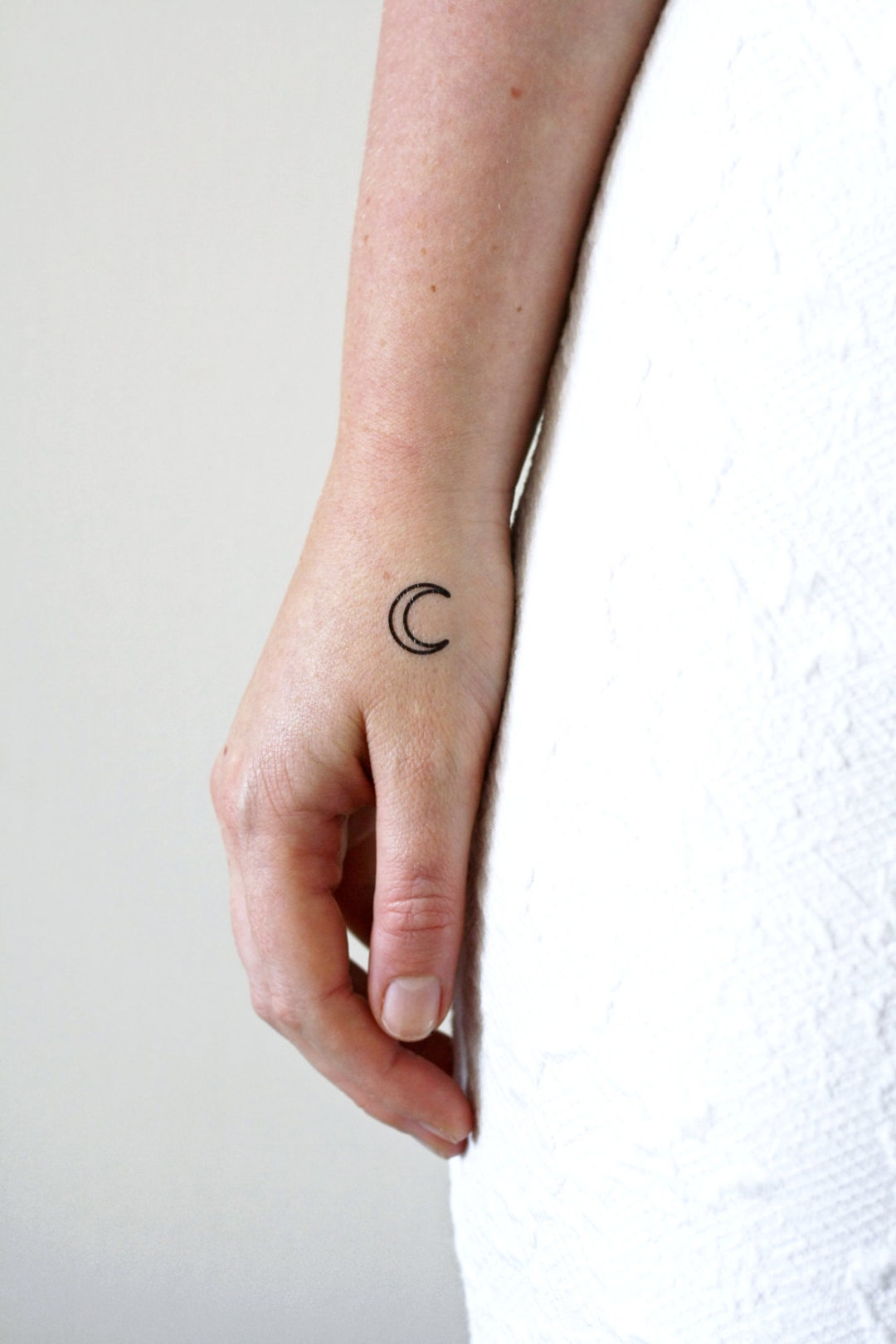 Hand poked crescent moon tattoo on the wrist