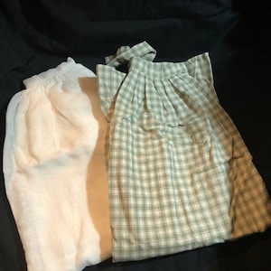 May include: Two pieces of fabric, one white and one green with a white and green plaid pattern.