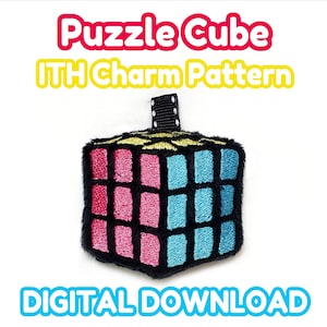 May include: A plush, embroidered puzzle cube charm with pink and blue squares, black borders, and a yellow top. The text "Puzzle Cube ITH Charm Pattern" and "DIGITAL DOWNLOAD" are displayed.