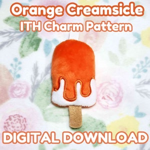 Puede incluir: Un charm de helado de naranja con detalles blancos goteando y un palito marrón. El texto "Orange Creamsicle ITH Charm Pattern" y "Digital Download" se muestra en naranja. El fondo presenta un estampado floral.