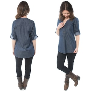 May include: A denim shirt with a button-down collar and rolled-up sleeves. The shirt is a dark blue color and has a relaxed fit. The model is wearing black leggings and brown boots.