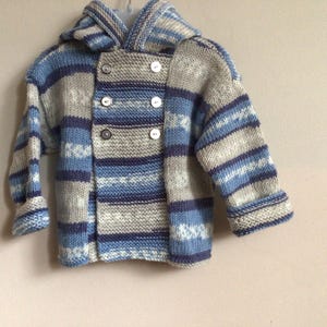 Handgestrickte Kapuzenjacke für Babys oder Kleinkinder im Alter von 12-18 Monaten. Perfekt für den ersten Geburtstag des Babys.