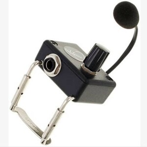 May include: A black clip-on microphone with a volume knob and a 1/4 inch jack. The microphone is attached to a black box with a silver clip.