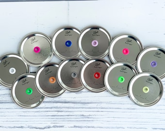 May include: Ten silver metal jar lids with different colored silicone rings. The lids are labeled "Ball SureTight".