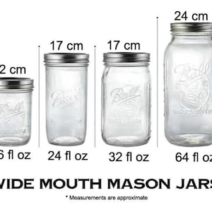 May include: Four clear glass Ball wide-mouth mason jars of varying sizes, with silver lids. The jars are labeled 16 fl oz (12 cm tall), 24 fl oz (17 cm tall), 32 fl oz (17 cm tall), and 64 fl oz (24 cm tall). The text "WIDE MOUTH MASON JARS" is below.