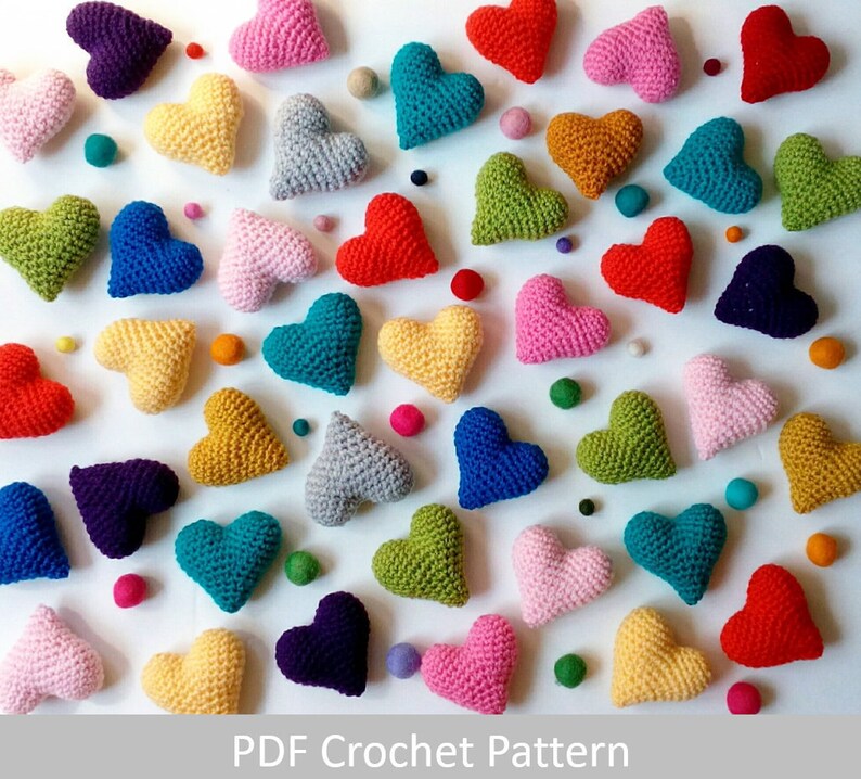 May include: A collection of crocheted hearts in various colors, including red, pink, blue, green, yellow, and purple. The hearts are arranged in a random pattern on a white background.  PDF Crochet Pattern
