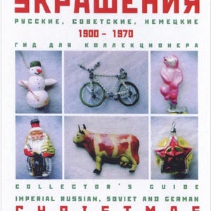 May include: A book cover with the title "ЁЛОЧНЫЕ УКРАШЕНИЯ" in Russian, which translates to "Christmas Ornaments". The cover features a collection of vintage Christmas ornaments, including a snowman, a bicycle, a pink bear, Santa Claus, a cow, and a star. The book is a collector's guide to Imperial Russian, Soviet, and German Christmas ornaments from 1900 to 1970.