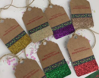 May include: Six brown gift tags with green and white ribbon and glitter. The tags have the text "HAVE YOURSELF A MERRY LITTLE CHRISTMAS" printed in red.