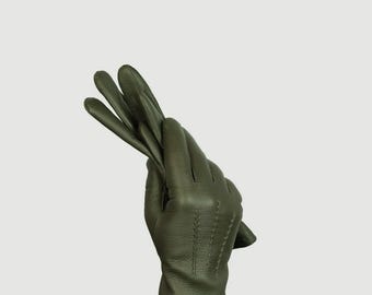 May include: A pair of green leather gloves folded in half, with the fingers pointing upwards.