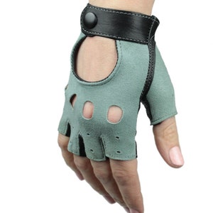 May include: A pair of fingerless driving gloves with a green suede palm and black leather wrist strap. The gloves have a button closure and finger holes.