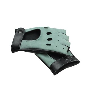 May include: A pair of fingerless gloves made of light blue suede with black leather trim and a button closure.